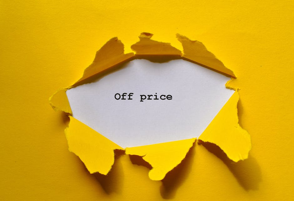 A torn yellow paper background reveals a white piece of paper with the words 'Off price' printed in black, creating a visual impression of a ripped hole. The torn edges of the yellow paper are irregular and curled outward, exposing the white paper underneath. The image is set against a matching yellow surface, consistent with a promotional or discount theme. Although the image focuses on a price reduction concept, it indirectly aligns with house removals or logistics by illustrating the idea of cost considerations, which are relevant to relocation and moving services. The image metaphorically suggests affordability and potential savings associated with efficient moving solutions from Man With a Van Aldersbrook, specialists in home relocation, furniture transport, packing, and loading processes. The lighting is even, emphasizing the contrast between the torn yellow paper and the clean white message, supporting clarity and accessibility for viewers.